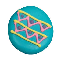 Four colorful Easter egg-shaped royal icing toppers with decorative patterns on a white background