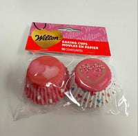 Red heart-shaped baking cups with packaging on a white background