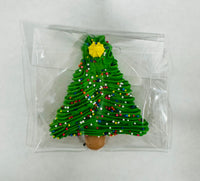 Christmas tree-shaped Sugar Royal Icing in a clear plastic bag on a white background