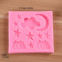 Pink silicone mold with star, cloud, and rose designs on a wooden surface