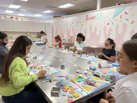 Children decorating cakes in a baking classroom