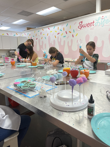 Children decorating cakes and cake pops in baking class in Miami
