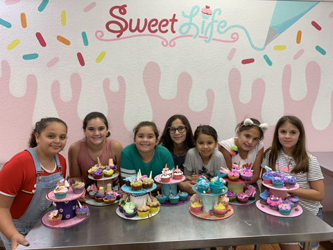 Children with colorful cupcakes they created in summer baking camp