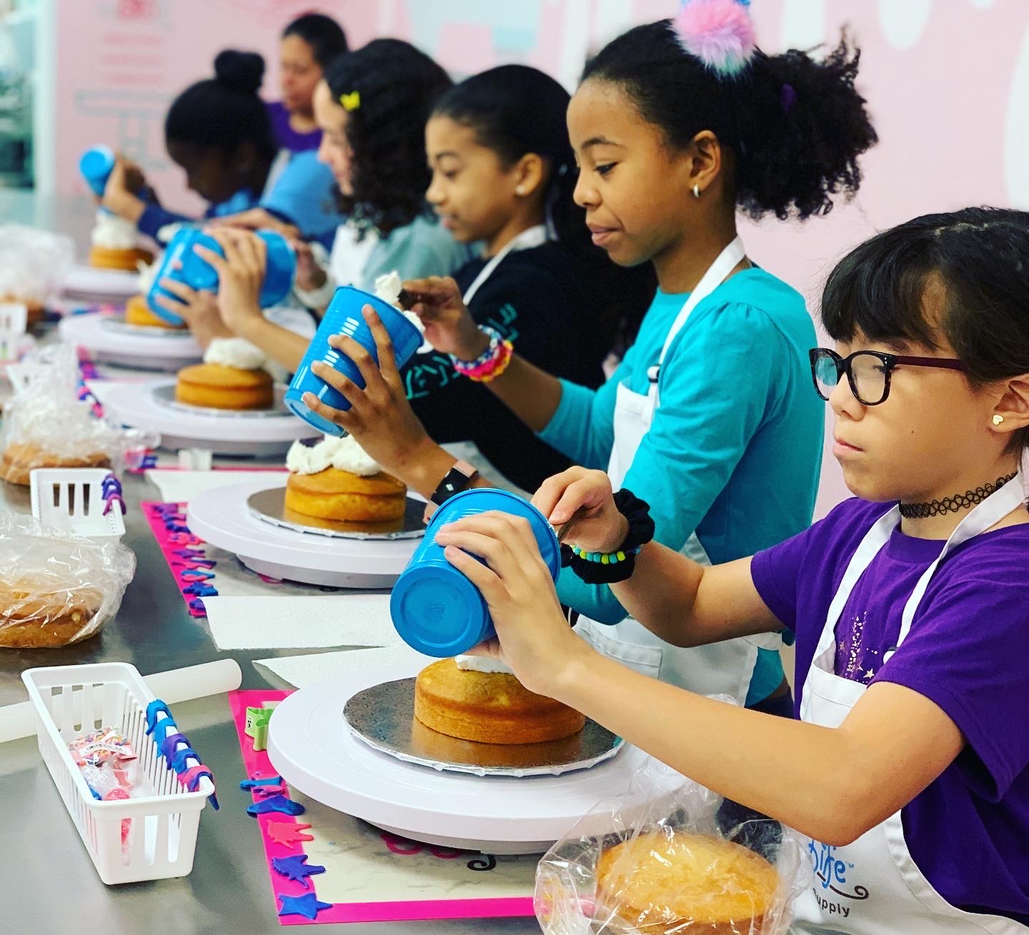 Children decorating cakes during baking class